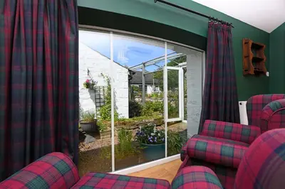 a living room with two chairs and a window at Craigadam Lodge with Hot tub in Castle Douglas