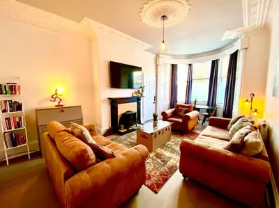 a living room with two couches and a fireplace at Historic 2-Bed Paisley Retreat, Airport & Station in Paisley