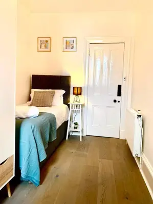 a bedroom with a bed and a ladder next to a door at Historic 2-Bed Paisley Retreat, Airport & Station in Paisley