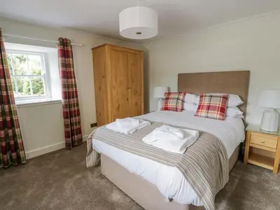 a bedroom with a large bed and a window at Garden House - Culzean Castle in Maybole