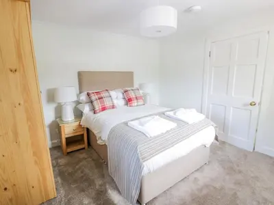 a bedroom with a bed with white sheets and red pillows at Garden House - Culzean Castle in Maybole