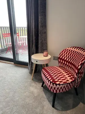 a chair and a table in a room with a window at Machrie View in Port Ellen