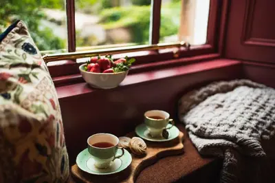 two cups of coffee on a table next to a window at Huntly House - A Residence Like No Other in Glasgow