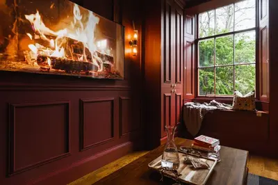 a living room with a fireplace and a table and a fire place at Huntly House - A Residence Like No Other in Glasgow
