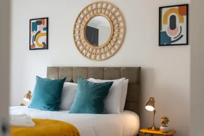a bedroom with a bed with blue pillows and a mirror at Ground Floor 2 Bed Flat Slateford in Edinburgh
