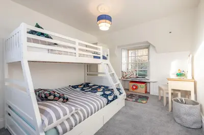 a bedroom with a bunk bed with a ladder at Charming Cardoon Cottage in beautiful village in Comrie