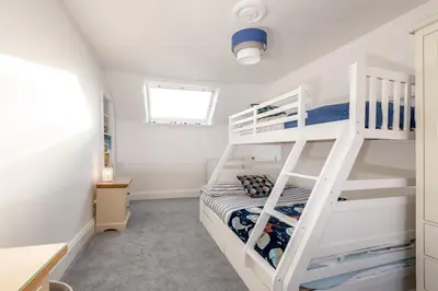 a bedroom with a bunk bed and a ladder at Charming Cardoon Cottage in beautiful village in Comrie