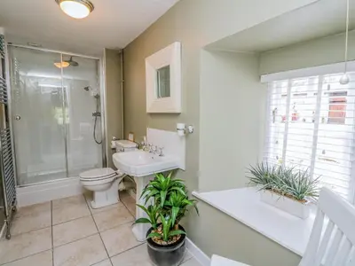a bathroom with a toilet and a shower and a sink at Inglis Nook Cottage in Lochearnhead