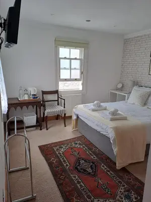 a bedroom with a bed and a chair and a window at B&B at No 4 in Biggar