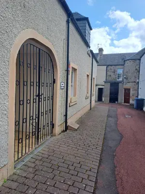 a gate on the side of a building with a brick street at B&B at No 4 in Biggar