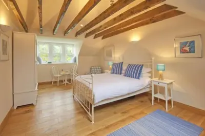 a bedroom with a bed with blue pillows on it at Achaglachgach Stables in Tarbert