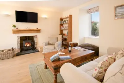 a living room with a table and a fireplace at The Old Farmhouse in Balloch