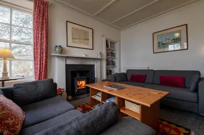 a living room with couches and a table and a fireplace at Rhunacairn in Oban