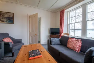a living room with a couch and a table at Rhunacairn in Oban
