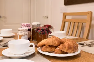 a table with a plate of croissants and a cup of coffee at Ardchyle House in Killin
