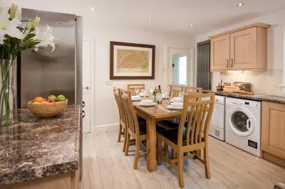 a kitchen with a table and chairs in a kitchen at Ardchyle House in Killin