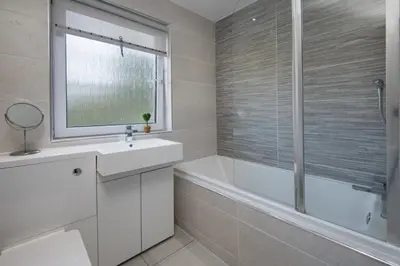 a bathroom with a white tub and a sink and a bath tubermott at Ardchyle House in Killin