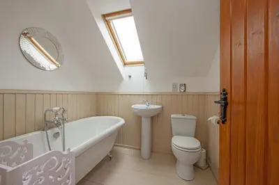 a bathroom with a tub and a toilet and a sink at Branter Lodge in Strachur