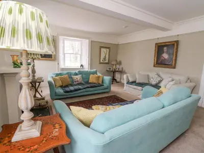 a living room with two blue couches and a lamp at Ardchattan Manse in Oban
