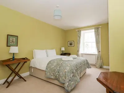a bedroom with a large bed and a window at Ardchattan Manse in Oban