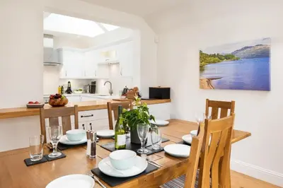 a kitchen and dining room with a table and chairs at Gaidrew Cottage in Drymen