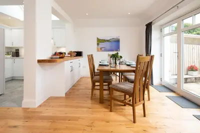a kitchen and dining room with a table and chairs at Gaidrew Cottage in Drymen