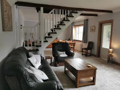 a living room with a couch and a staircase at Arrochar Fern Cottage with Wood Burner & Loch View in Arrochar