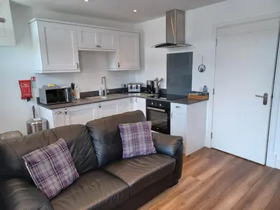 a living room with a couch and a kitchen at CRAIGLEA HEATHER in Killin