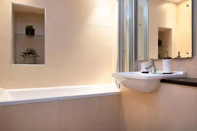 a bathroom with a sink and a mirror at JOIVY Luxury Flat near Edinburgh Castle in Edinburgh