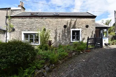 an old stone house with a garden in front of it at Yewtree Cottage - 'The Art House' and Garden in Hunters Quay