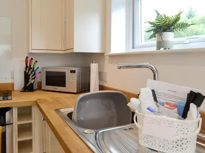a kitchen sink with a dish drying rack in it at Boatman's Cottage At Invernian Mor in Inverinan Beg