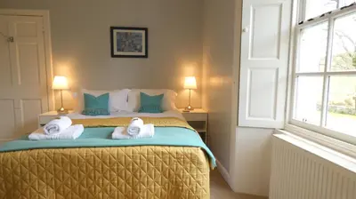 a bedroom with a bed with towels on it at Kirkland House B&B in Tarbert