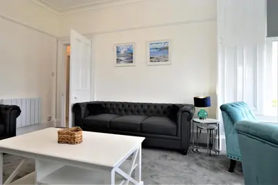 a living room with a couch and a table at Findhorn Upper Apartment in Kames
