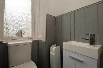 a bathroom with a toilet and a sink and a window at Findhorn Upper Apartment in Kames