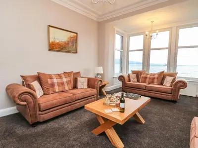 a living room with two couches and a table at Argyle House in Rothesay