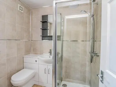 a bathroom with a shower and a toilet and a sink at Argyle House in Rothesay