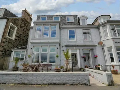 a large house with a bench in front of it at Argyle House in Rothesay