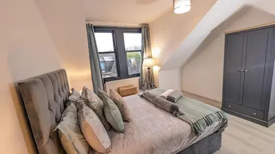 a large bed in a room with a large window at Lovely 2 Bedroom Apartment in Central Location in Greenock
