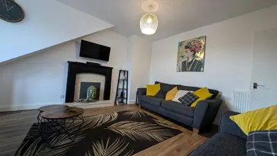 a living room with a couch and a fireplace at Lovely 2 Bedroom Apartment in Central Location in Greenock