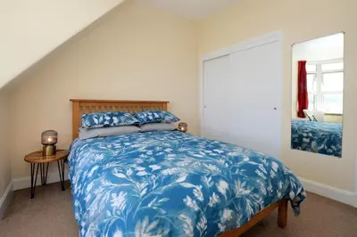 a bedroom with a bed with a blue comforter at Arran View in Lochgilphead