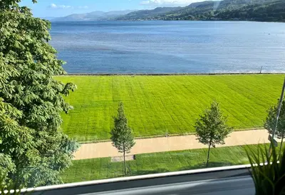 a view of a field of grass and a lake at Arran View in Lochgilphead