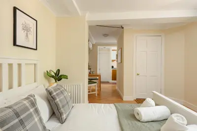 a bedroom with a white bed and a hallway at Dean Village Hideaway by Calton Living in Edinburgh