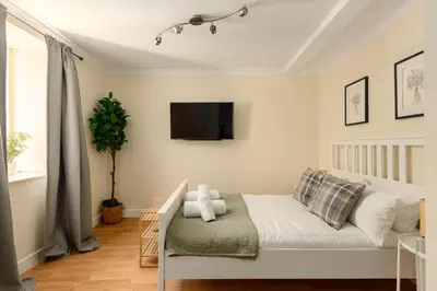 a bedroom with a bed and a tv on the wall at Dean Village Hideaway by Calton Living in Edinburgh