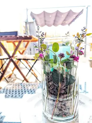 a vase filled with rocks and flowers on a table at Rural Private Lodge - With Hot Tub - Outdoor Kitchen and Covered Lounge for Two in Crook of Devon