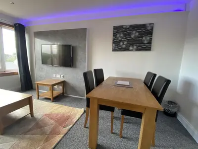 a conference room with a wooden table and chairs at Pure Apartments Fife - Dunfermline - Pitcorthie in Dunfermline