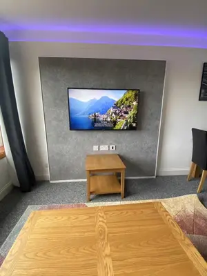 a living room with a flat screen tv on a wall at Pure Apartments Fife - Dunfermline - Pitcorthie in Dunfermline