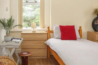 a bedroom with a bed with a red pillow on it at Lotus Studio near Lanark in Carstairs