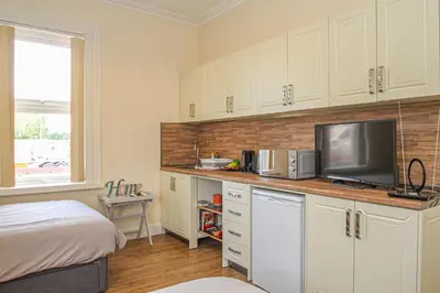 a bedroom with a bed and a tv in a room at Lotus Studio near Lanark in Carstairs