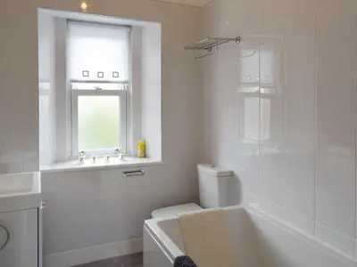 a bathroom with a tub and a toilet and a window at Charlotte Street in Ayr