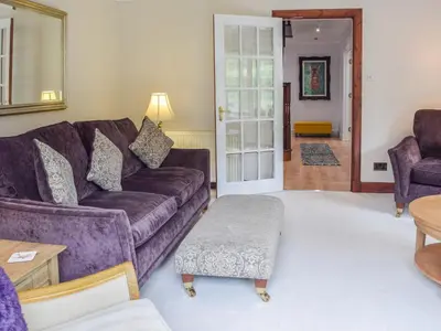a living room with a purple couch and a table at Tamarchan Lodge in Ballachulish